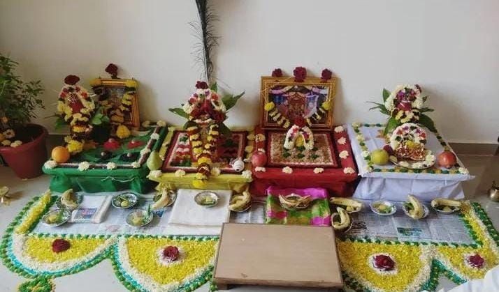 Colorful Hindu altar decorated with flowers, fruits, and offerings for a religious ceremony.