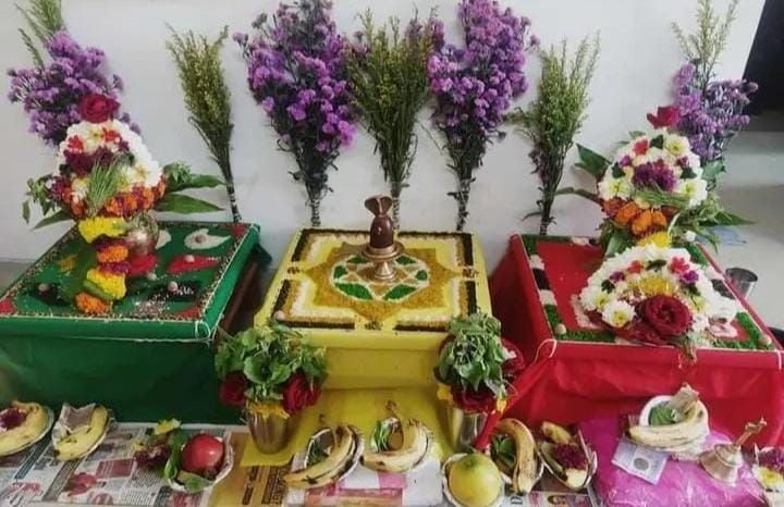 Decorated altar with flowers, fruits, and colorful fabrics for a traditional religious ceremony.