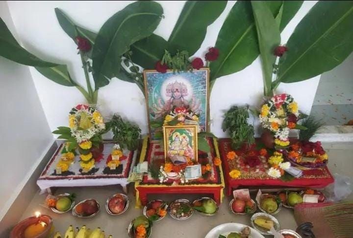 Hindu altar with decorated images, offerings, and banana leaves in a religious setting.