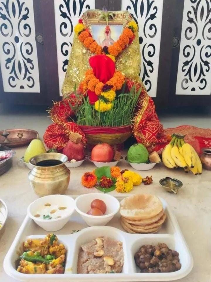 Traditional Indian offering with food platter, fruits, and floral arrangements for a religious ceremony.